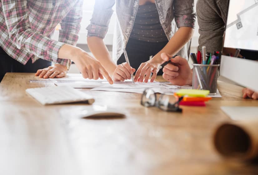 Team reviewing building plans together at a desk