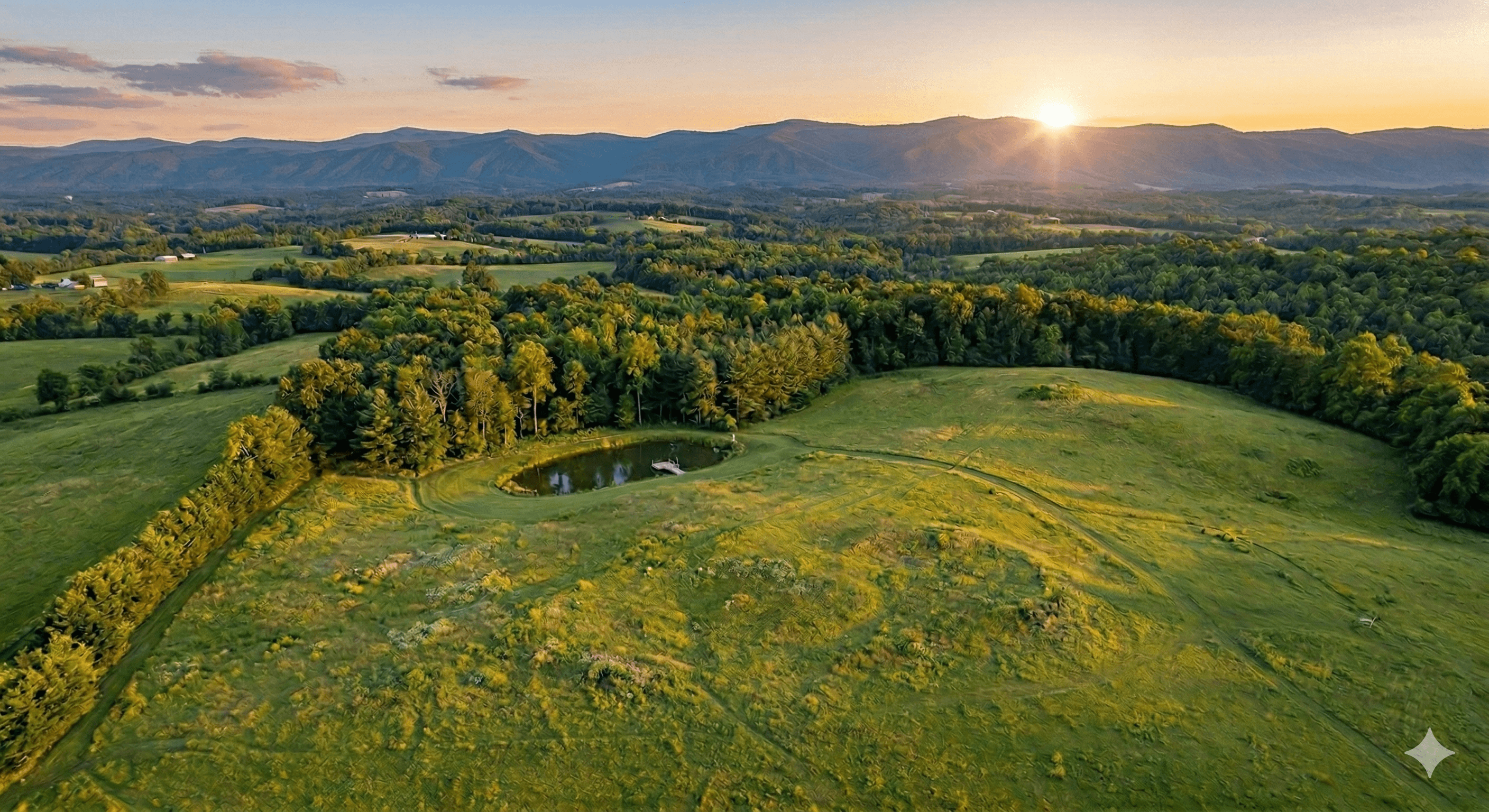 Aerial view of rolling green Virginia Piedmont farmland with Blue Ridge Mountains at sunset